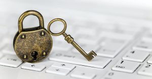 Key and padlock on a white computer laptop keyboard, internet privacy banner