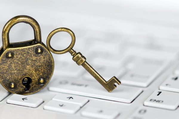 Key and padlock on a white computer laptop keyboard, internet privacy banner