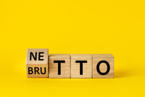 Netto and brutto. Net and gross symbol. Words on wooden blocks change net to gross. Financial concept, Beautiful yellow background, copy space