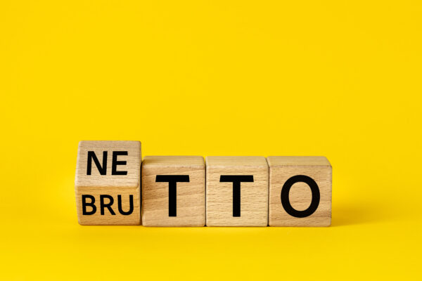 Netto and brutto. Net and gross symbol. Words on wooden blocks change net to gross. Financial concept, Beautiful yellow background, copy space