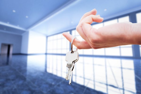 Woman's hand holding the keys to an apartment.